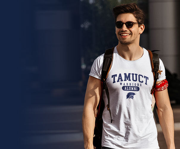 A muscular guy is wearing a TAMUCT Warriors Alumni t-shirt