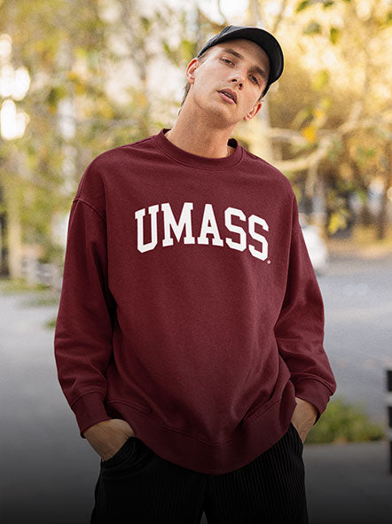 A guy is wearing a University of Massachusetts sweatshirt of Arch design