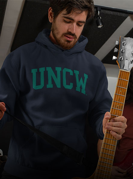 A guy is wearing a University of North Carolina Wilmington hoodie of college design