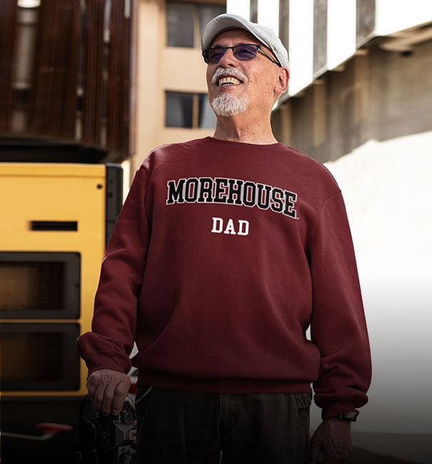 An aged man is wearing Morehouse College sweatshirt with word dad