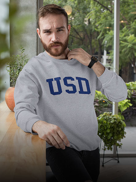 A man is wearing University of South Dakota sweatshirt of game day design