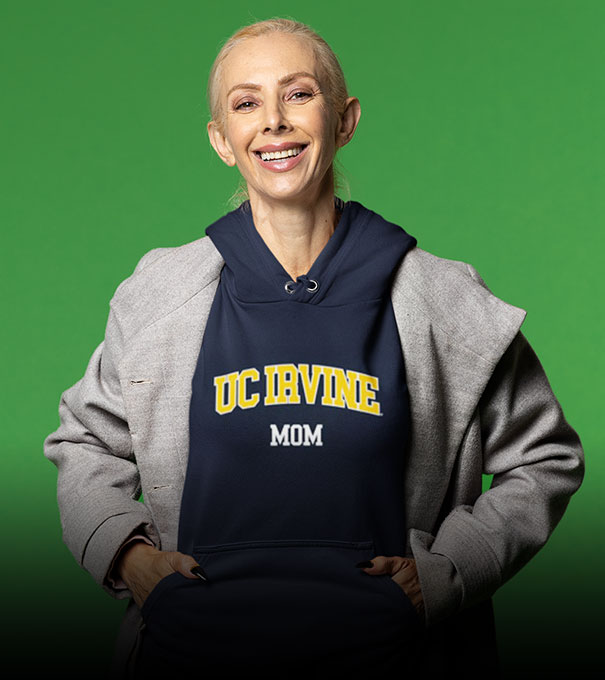 A woman is wearing a University of California UC Irvine Anteaters hoodie with word mom