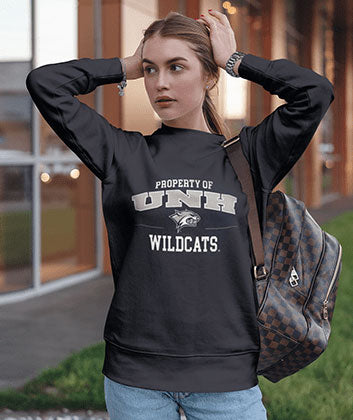 A girl wearing a Property of UNH Wildcats sweatshirt