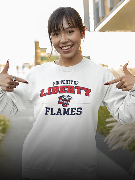 A girl is wearing a Liberty University Flames sweatshirt of property design