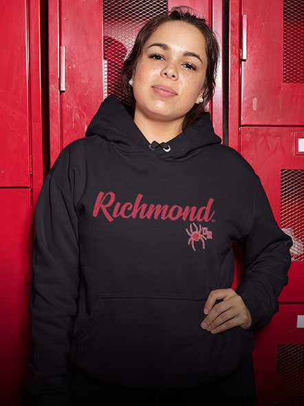 A girl is wearing a University of Richmond hoodie of script design