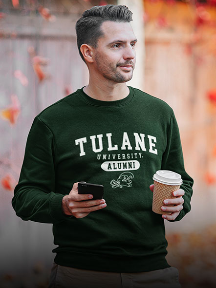 A man is wearing a Tulane University sweatshirt of alumni design