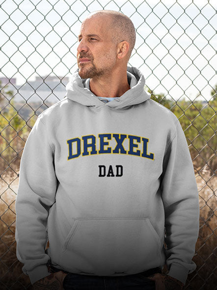 A man is wearing a Drexel University Dragons hoodie with word dad