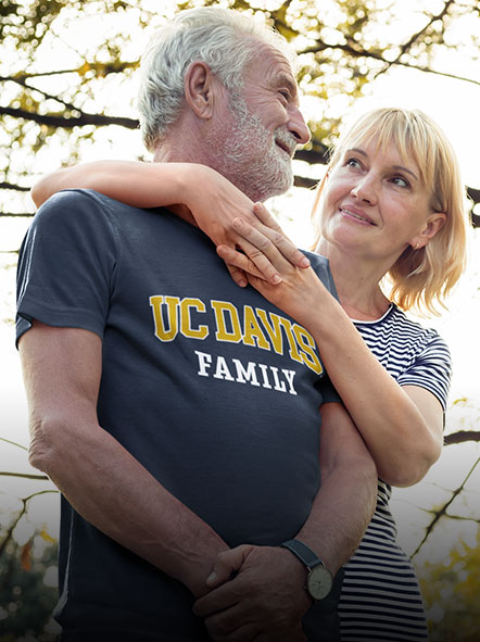 An aged couple wearing a UC Davis University t-shirt of family design