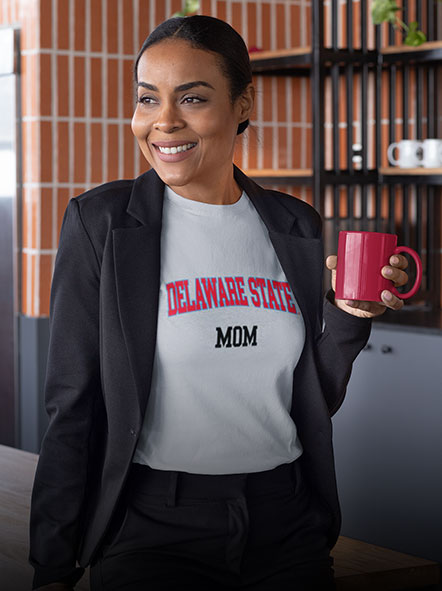 A black woman is wearing a Delaware State University Hornet t-shirt with word mom